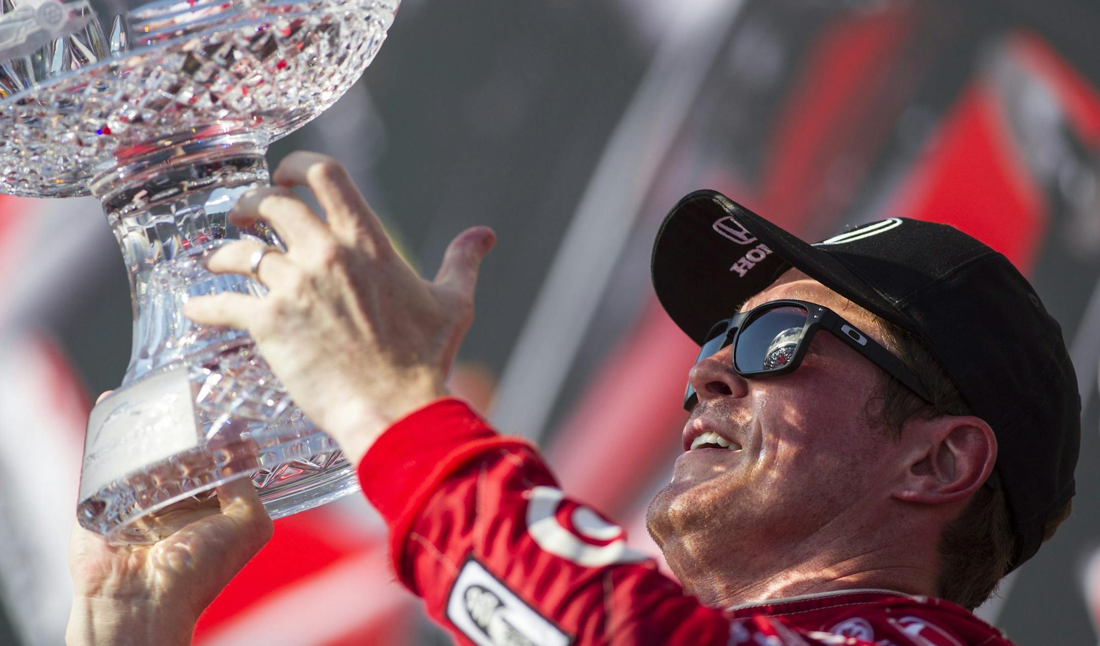 Scott Dixon, of New Zealand, lifts the trophy after winning the IndyCar auto race in Toronto on Sunday, July 14, 2013. (AP Photo/The Canadian Press, Chris Young)