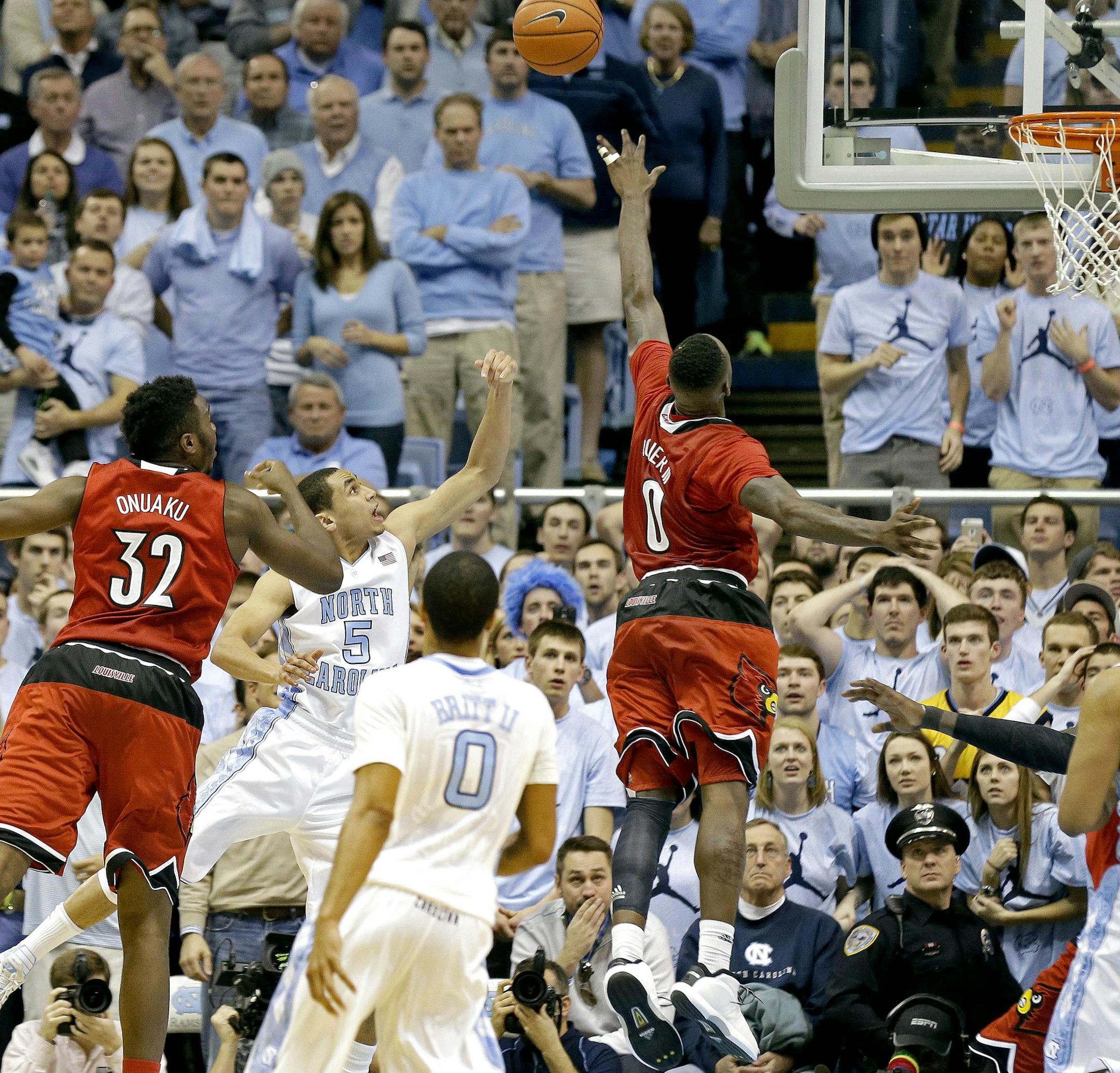 North Carolina's Marcus Paige (5) shoots the game winning basket as Louisville's Chinanu Onuaku (32) and Terry Rozier (0) defend during the second half of an NCAA college basketball game in Chapel Hill, N.C., Saturday, Jan. 10, 2015. North Carolina won 72-71. North Carolina's Nate Britt (0) and Kennedy Meeks (3) watch. (AP Photo/Gerry Broome)