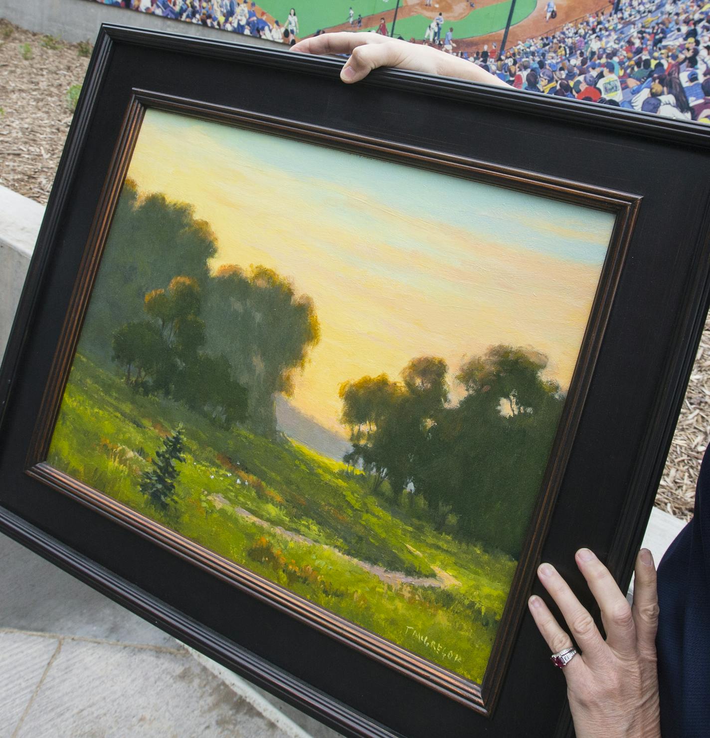 The tour update photos for the New Saints CHS stadium in downtown St. Paul. Photos to be use for an illustration package 051715___ Tom McGregor's Painting, "Bruce Vento at Daybreak" . Holding the painting is Annie Huidekoper, Vice President, Community Partnerships & Customer Service St. Paul Saints Baseball Club CHS Field, 360 Broadway St. ORG XMIT: MIN1505141643310673