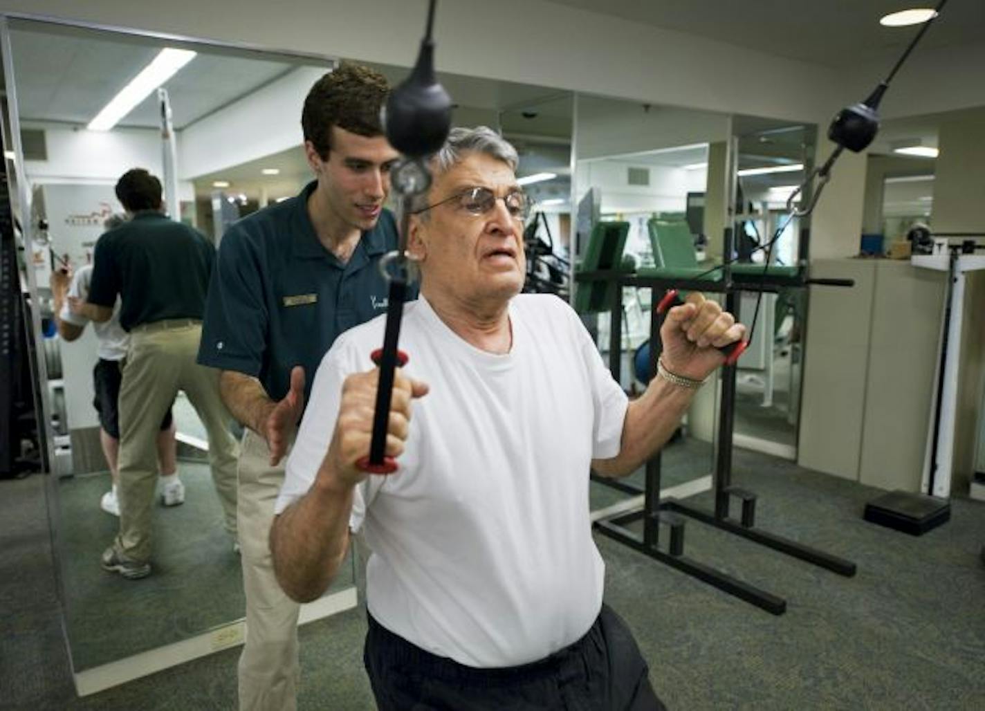 Dean Constantine does a strengthening exercise under the guidance of Marsh exercise specialist, Mike Bialick.