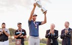 Dustin Johnson hoisted the trophy on the 18th green after winning the U.S. Open on Sunday, even after coping with a pending penalty ruling over his he