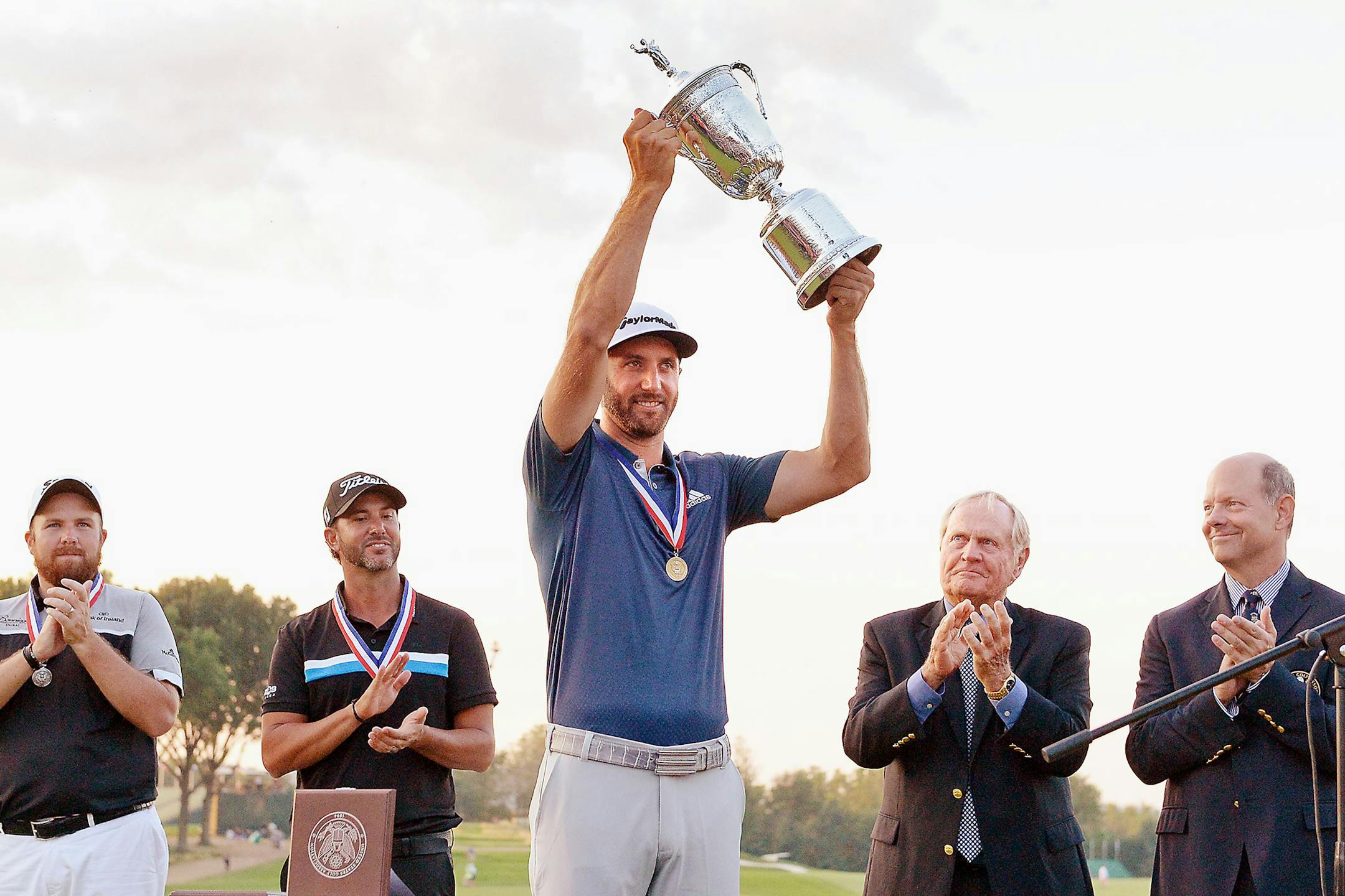 Dustin Johnson hoisted the trophy on the 18th green after winning the U.S. Open on Sunday, even after coping with a pending penalty ruling over his head for much of the final round.