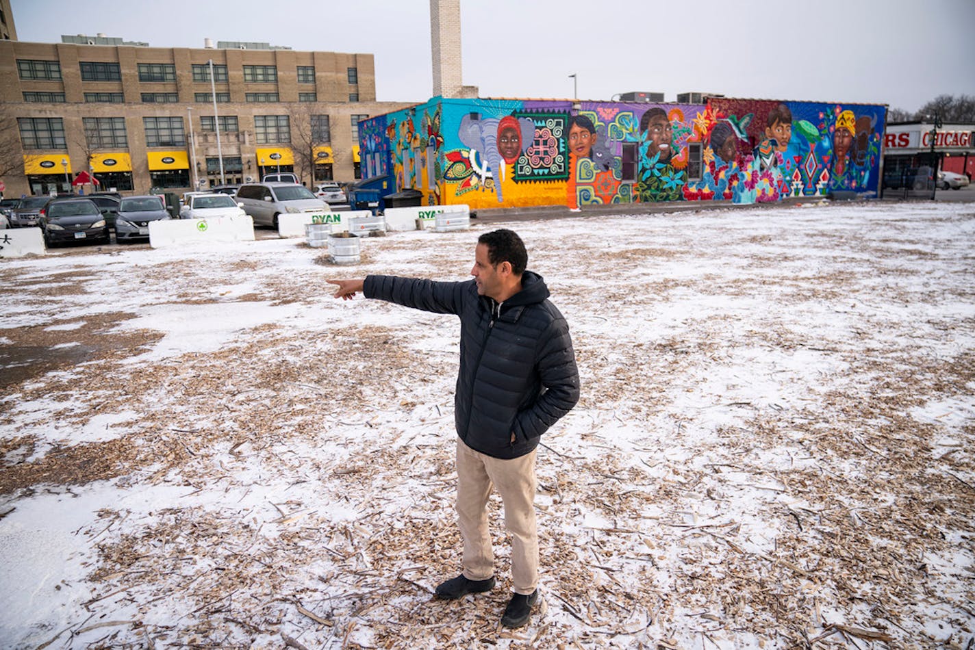 Faisal Demaag, owner of Chicago Furniture Warehouse, discusses the former layout of his store on the plot of land where it used to be Friday, Dec. 17, 2021 in Minneapolis, Minn. He owned the store for 27 years before it burned down during the protests following the murder of George Floyd in 2020. ]