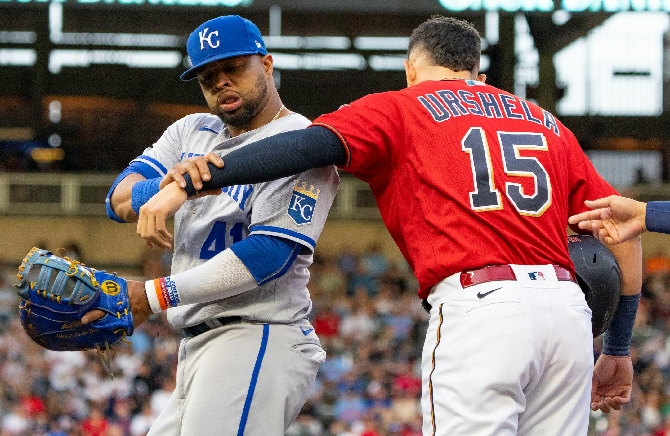 Kansas City Royals first baseman Carlos Santana (41) throws off the arm of Minnesota Twins third baseman Gio Urshela (15) after he had put his arm around Santana in the first inning.