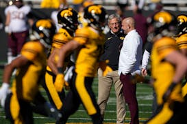 Gophers coach P.J. Fleck, middle right, spoke with Iowa coach Kirk Ferentz during warmups before Minnesota’s 12-10 victory Saturday.