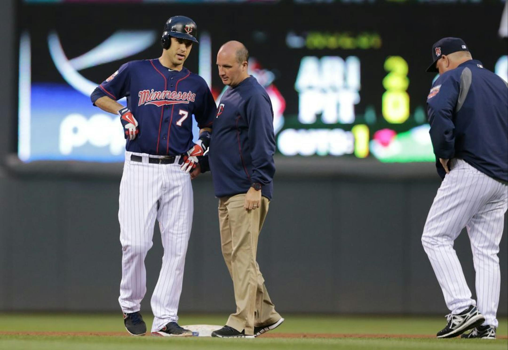 Joe Mauer, left, is checked by a trainer as manager Ron Gardenhire, right, comes out after Mauer's two-run double off Kansas City Royals pitcher James Shields in the fourth inning of a game, Tuesday, July 1, 2014, in Minneapolis. Mauer later left the game and has not played since.