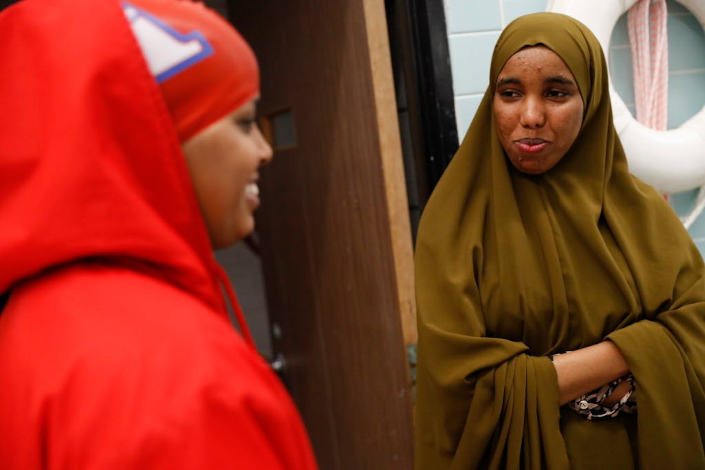 Nimo Gohe, right, chatted with Suhan Mohamed before a swim meet at Apollo High School in St. Cloud, Minn., on Thursday, October 5, 2017.