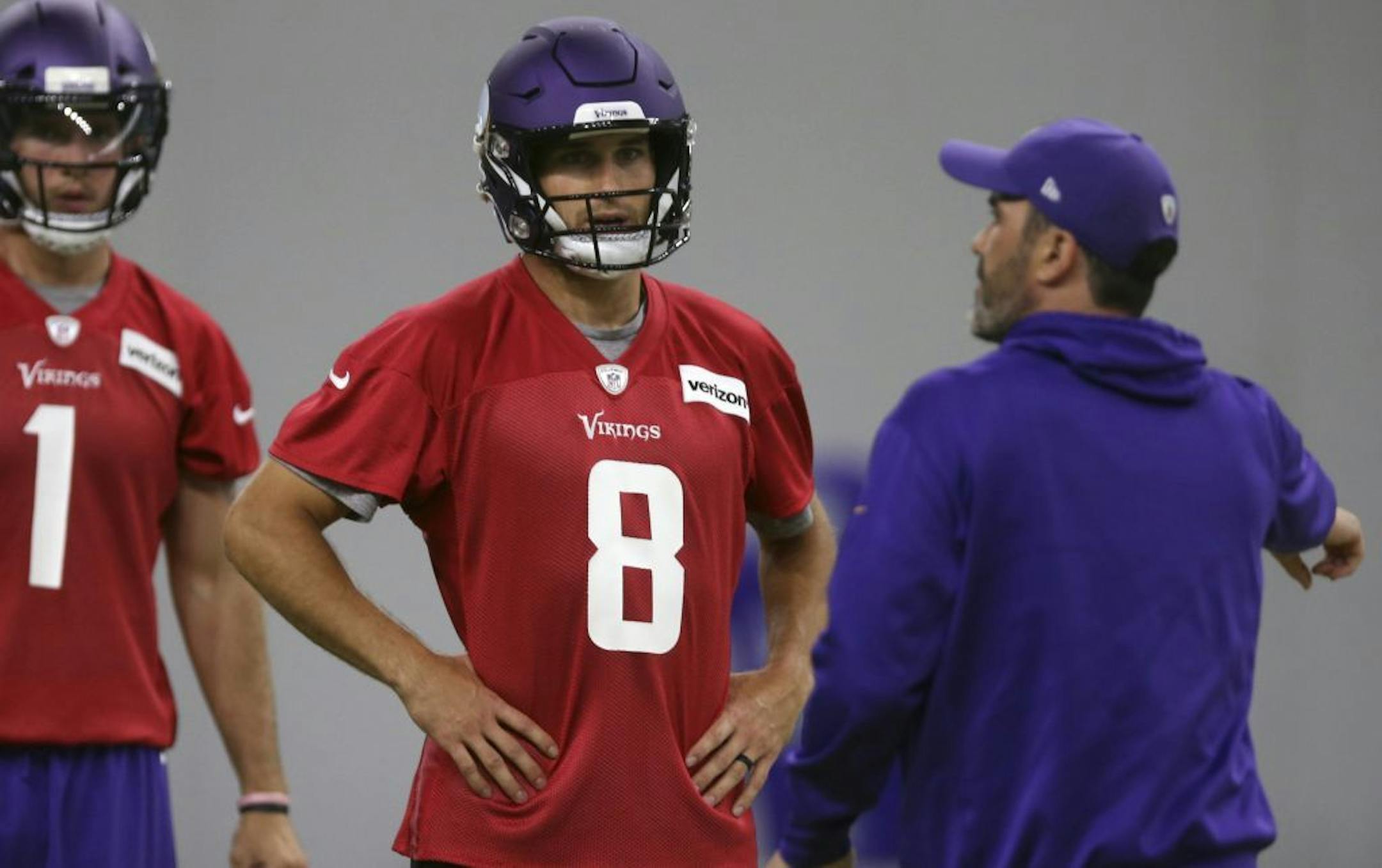Minnesota Vikings quarterback Kirk Cousins (8) listens to instructions from quarterback coach Kevin Stefanski during practice at the NFL football team's training camp Wednesday, May 30, 2018, in Eagan, Minn. Cousins is the quarterback with the first fully guaranteed contract in NFL history, but he's also being careful not to force his way into the role of the team leader and confident it will happen organically throughout the year. At left is backup quarterback Kyle Sloter.