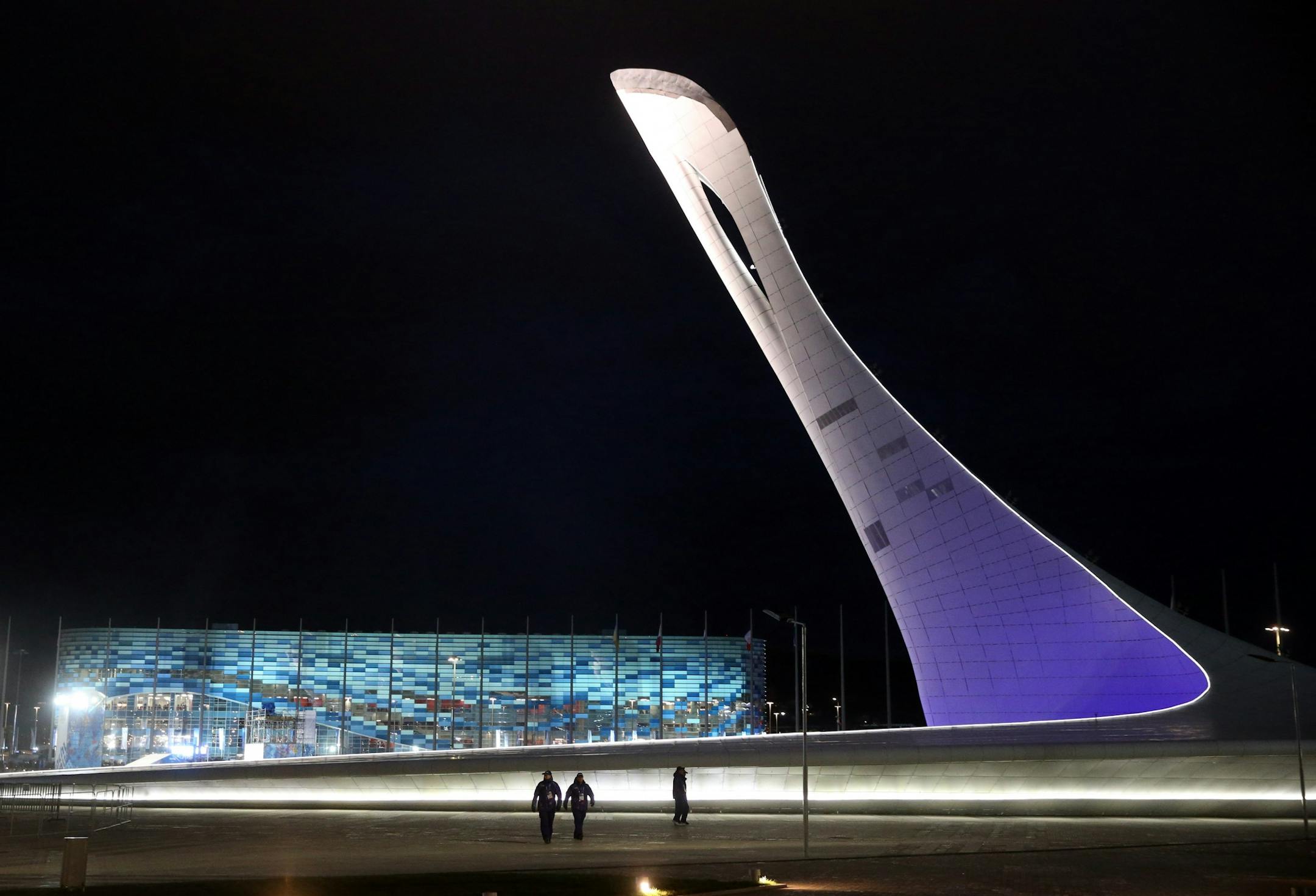 The unlit Olympic torch and Iceberg Skating Palace on the night before opening ceremonies at the Winter Olympics in Sochi, Russia, Thursday, Feb. 6, 2014.