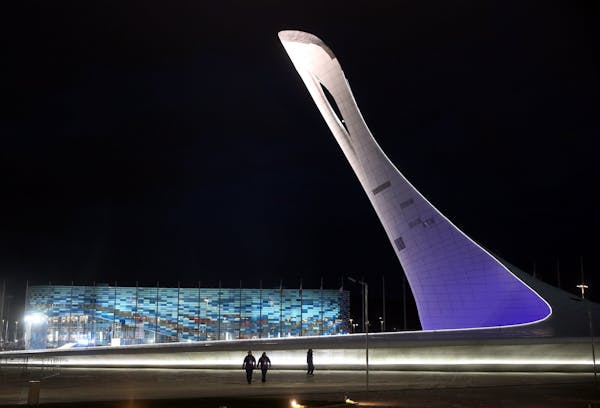 The unlit Olympic torch and Iceberg Skating Palace on the night before opening ceremonies at the Winter Olympics in Sochi, Russia, Thursday, Feb. 6, 2