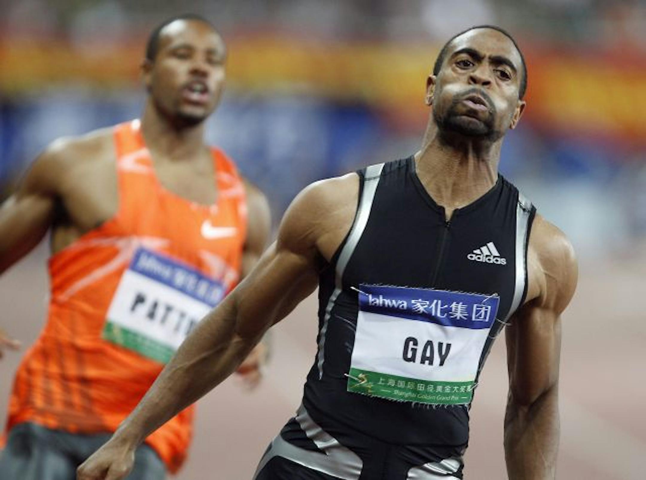 Tyson Gay of the United States, right, reacts as he crosses the finish line as his compatriot Darvis Patton, left, follows after their 100 meter men race during at 2009 Shanghai Golden Grand Prix, an international field and track event, Sunday Sept. 20, 2009 at Shanghai Stadium in Shanghai, China. Gay won the competition with the time of 9.69 and Patton finished in third place.