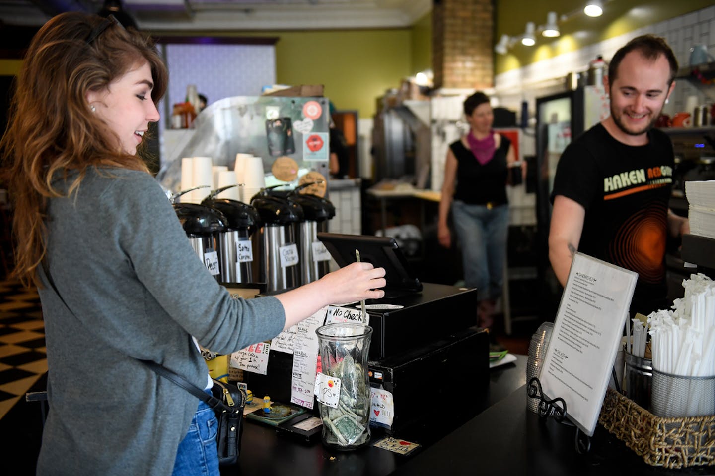 Barista Andy Regan, right, watched as Jennifer Ivers, of Minneapolis, placed a dollar in the tip jar Wednesday afternoon at Maeve's Cafe. ] AARON LAVINSKY &#x2022; aaron.lavinsky@startribune.com Restaurants owners are preparing to make their last stand against a Minneapolis minimum wage that doesn't count tips as wages. We photograph Maeve's Cafe on Wednesday, May 24, 2017 in Minneapolis, Minn.