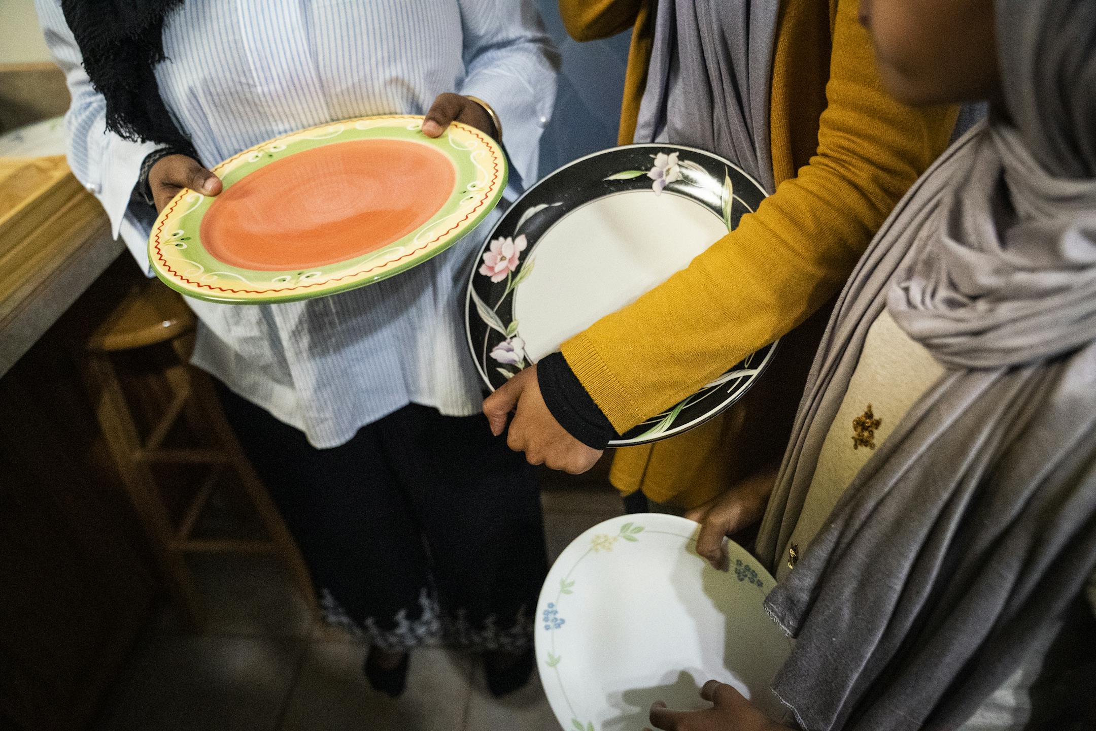 Women line up with real plates during Iftar dinner at Club ICM. ] LEILA NAVIDI ¥ leila.navidi@startribune.com BACKGROUND INFORMATION: Iftar potluck dinner during Ramadan at Club ICM in Fridley on Tuesday, May 14, 2019. For a story on initiatives taken by different Muslim organizations to ensure minimum wastage of food and minimal trash waste during Ramadan and Iftar get togethers.