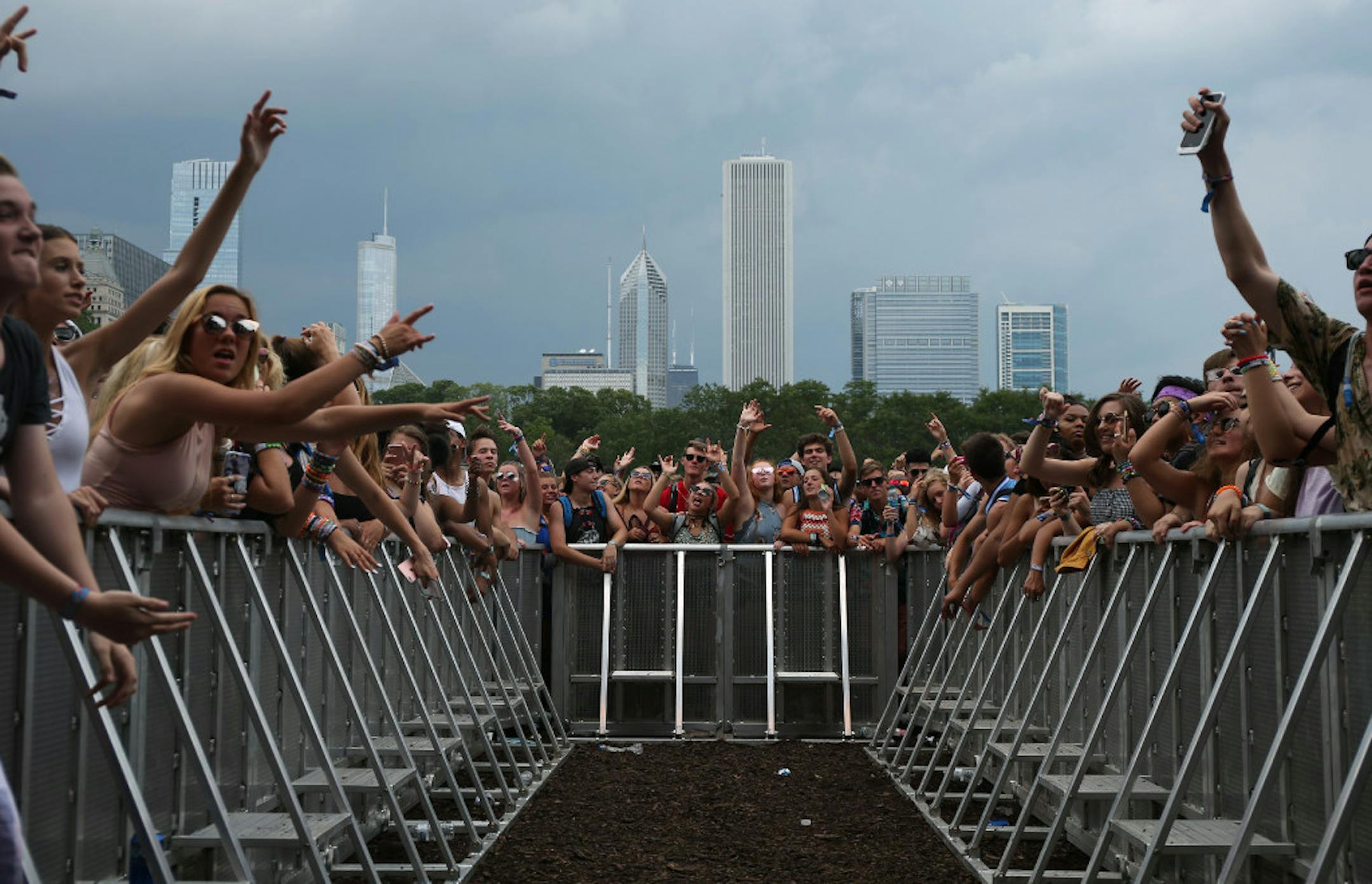 Concertgoers cheer as the band White Reaper takes the stage during Lollapalooza at Grant Park in Chicago on Thursday, Aug. 3, 2017.