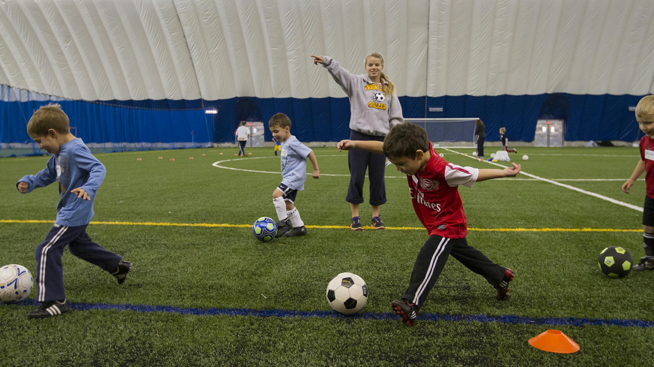 Coach Samantha Provost (cq/source), a junior at Prior Lake High School, instructed her group to dribble down the field towards a goal box. ] MARISA WOJCIK - Savage, Minnesota's new sports dome opened to the public for the first time on Thursday evening, November 1, 2012. The Prior Lake Soccer Club held soccer practice for it's three to five year olds in the dome's 104,000 square foot space. The facility is equipped with a turf field and batting cage. ORG XMIT: MIN1211012004015419