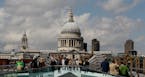 Pedestrians walk across the Millenium Bridge in front of St Paul's Cathedral in London, Thursday, June 16, 2011. The cathedral is seen without scaffol