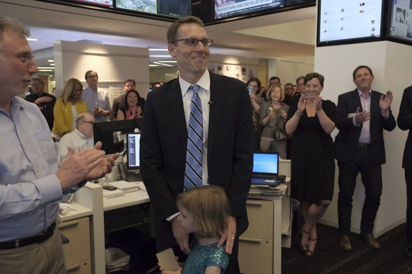 David Fahrenthold, center, was congratulated upon learning that he won the Pulitzer Prize for National Reporting, for dogged reporting of Donald Trump's philanthropy, in the newsroom of the Washington Post in Washington on Monday, April 10, 2017.