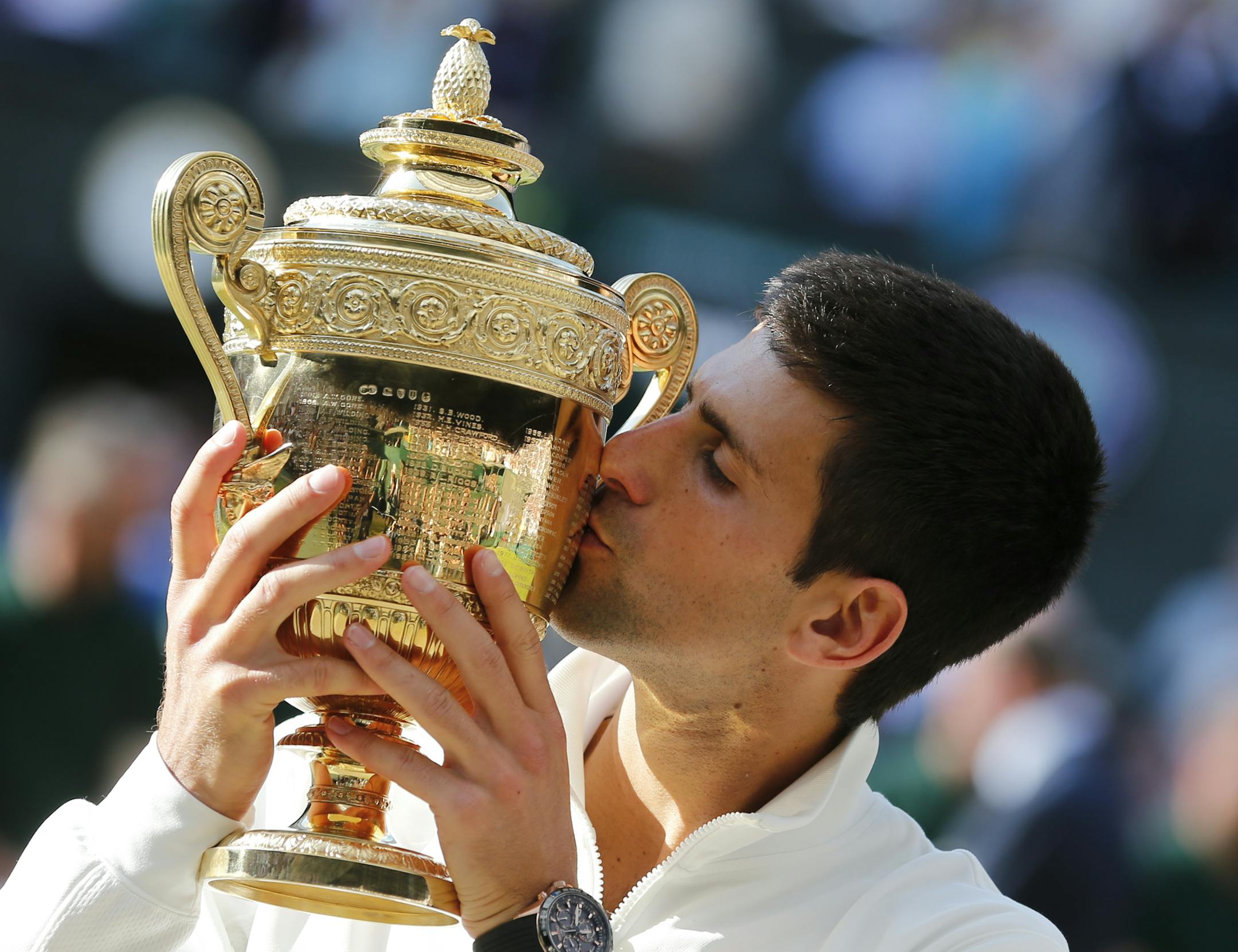 Novak Djokovic of Serbia kisses the trophy after defeating Roger Federer of Switzerland in the men's singles final at the All England Lawn Tennis Championships in Wimbledon, London, Sunday July 6, 2014. (AP Photo/Ben Curtis)