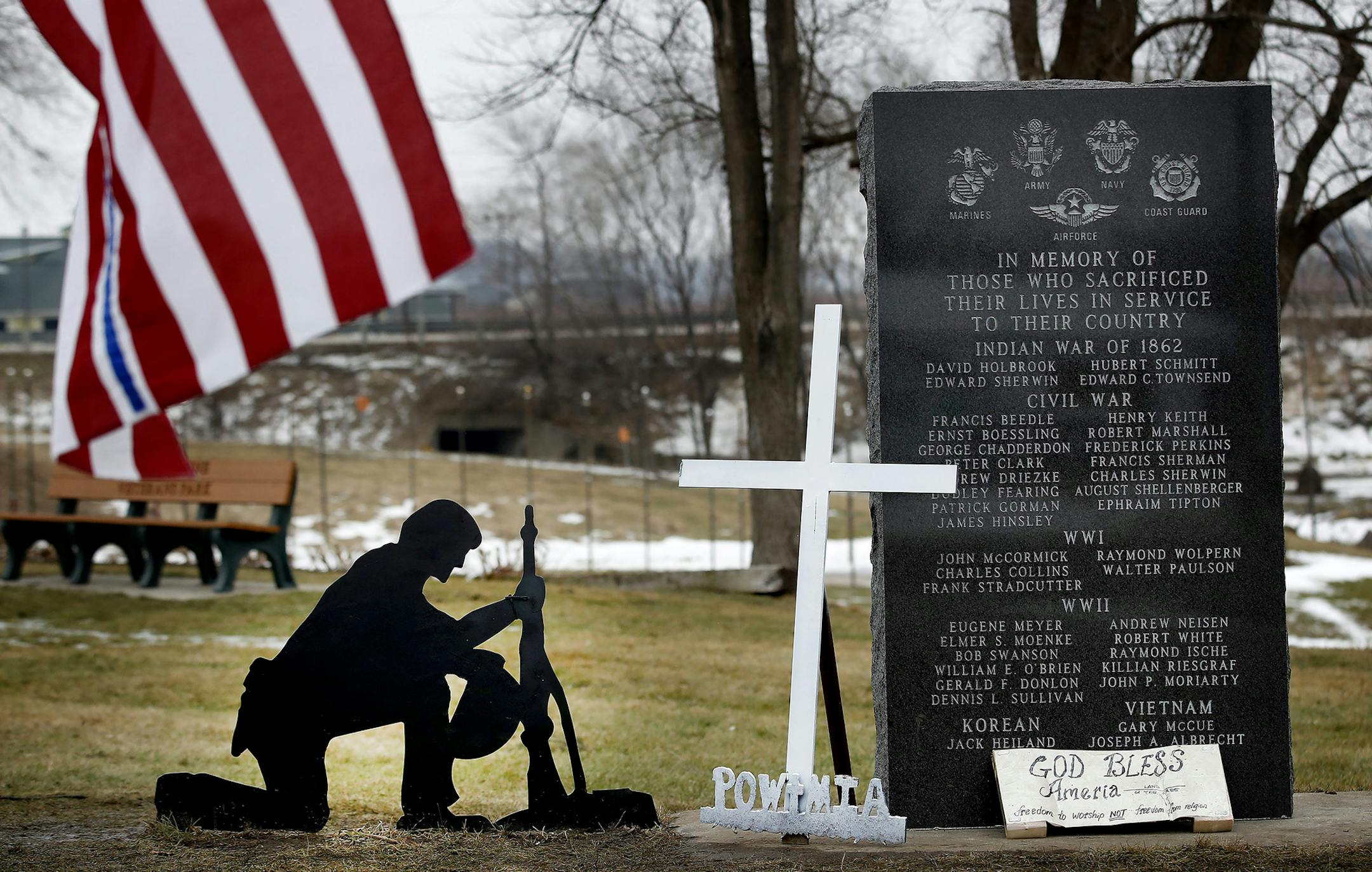 A cross was removed from a kneeling soldier at the veterans memorial park in Belle Plaine, MN. Advocates for the cross have been placing new ones at the park and guarding them throughout the day. ] CARLOS GONZALEZ cgonzalez@startribune.com - January 24, 2017, Belle Plaine, MN, A group of flag-toting Belle Plaine residents has taken it upon themselves to keep guard over the small town's veteran's memorial, rebelling against city's decision to remove a cross from a fallen soldier's grave marker. O