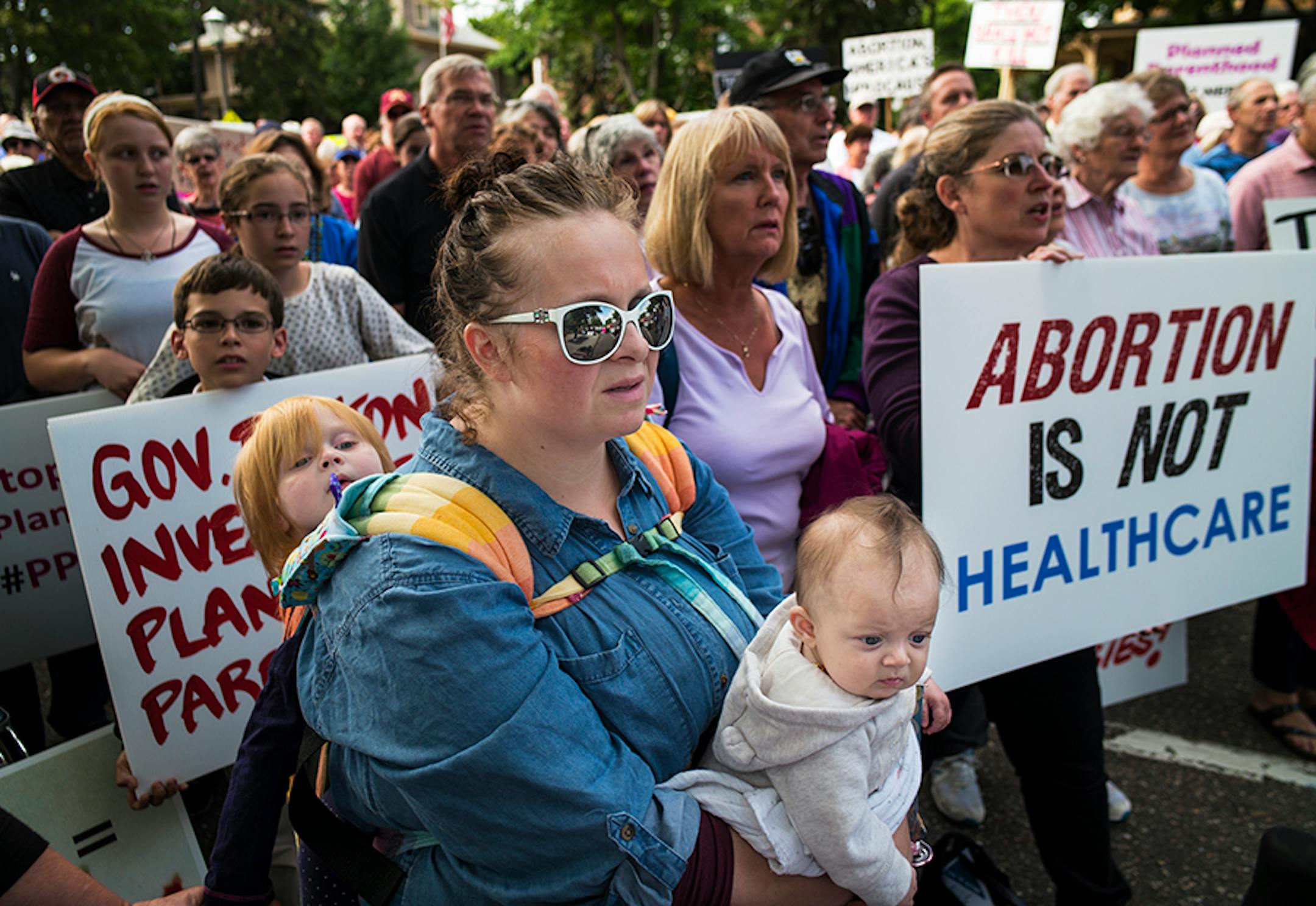 In front of the governor's mansion in St. Paul, pro-life activists gathered to ask Gov. Mark Dayton to investigate Planned Parenthood and calling for legislators to defund the organization. Kacey Porter of Hastings with her daughters Roxanna, 3 months, and Penelope,3, came because they do not want tax payers funding Planned Parenthood.