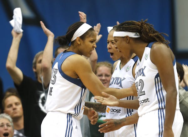 Lynx Seimone Augustus and Rebekkah Brunson celebrated with teammate Maya Moore after she blocked the shot of the Storm's Katie Smith during the second