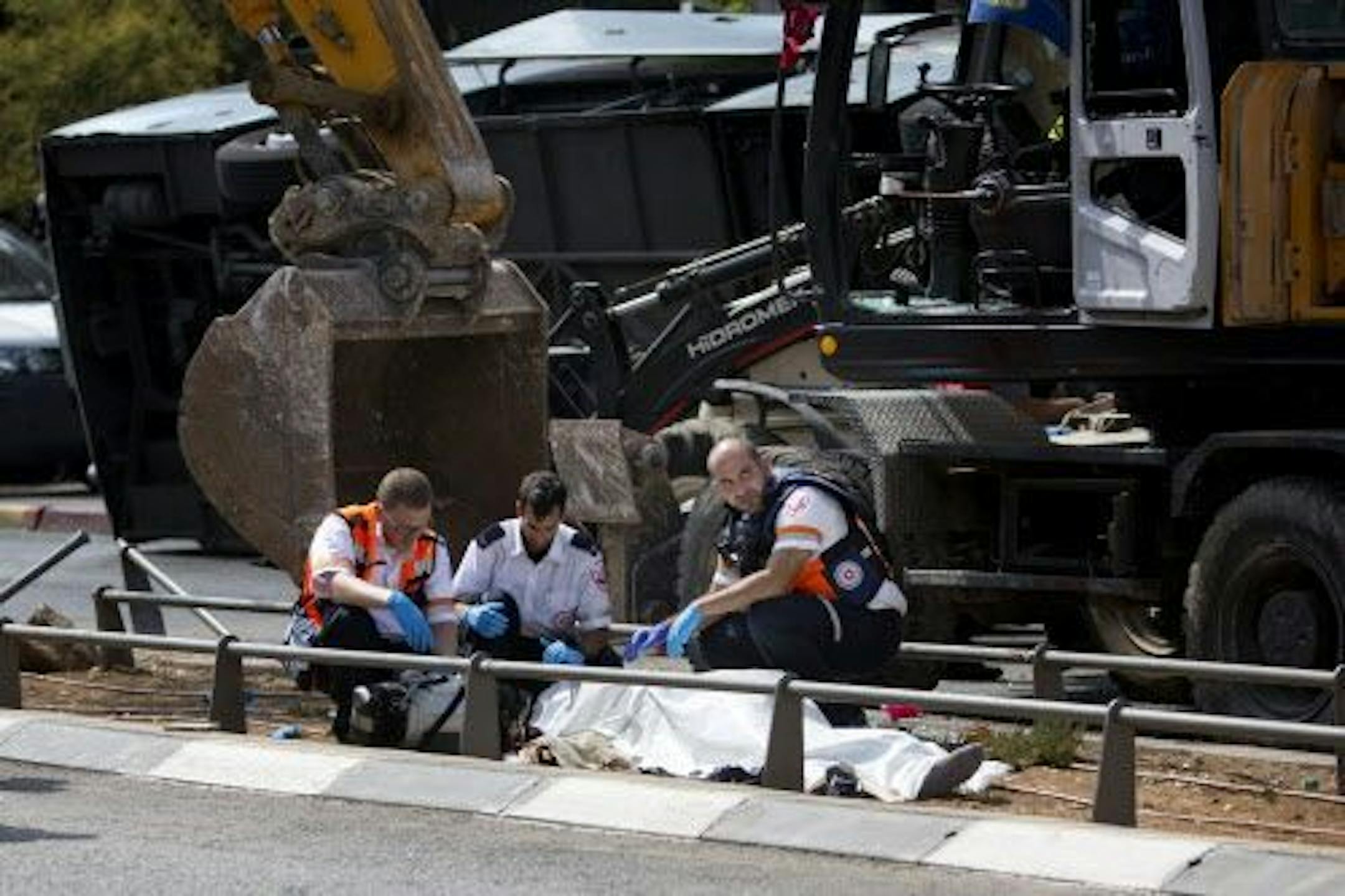 Israeli medics inspect a body at the scene of an attack in Jerusalem, Monday, Aug. 4, 2014.