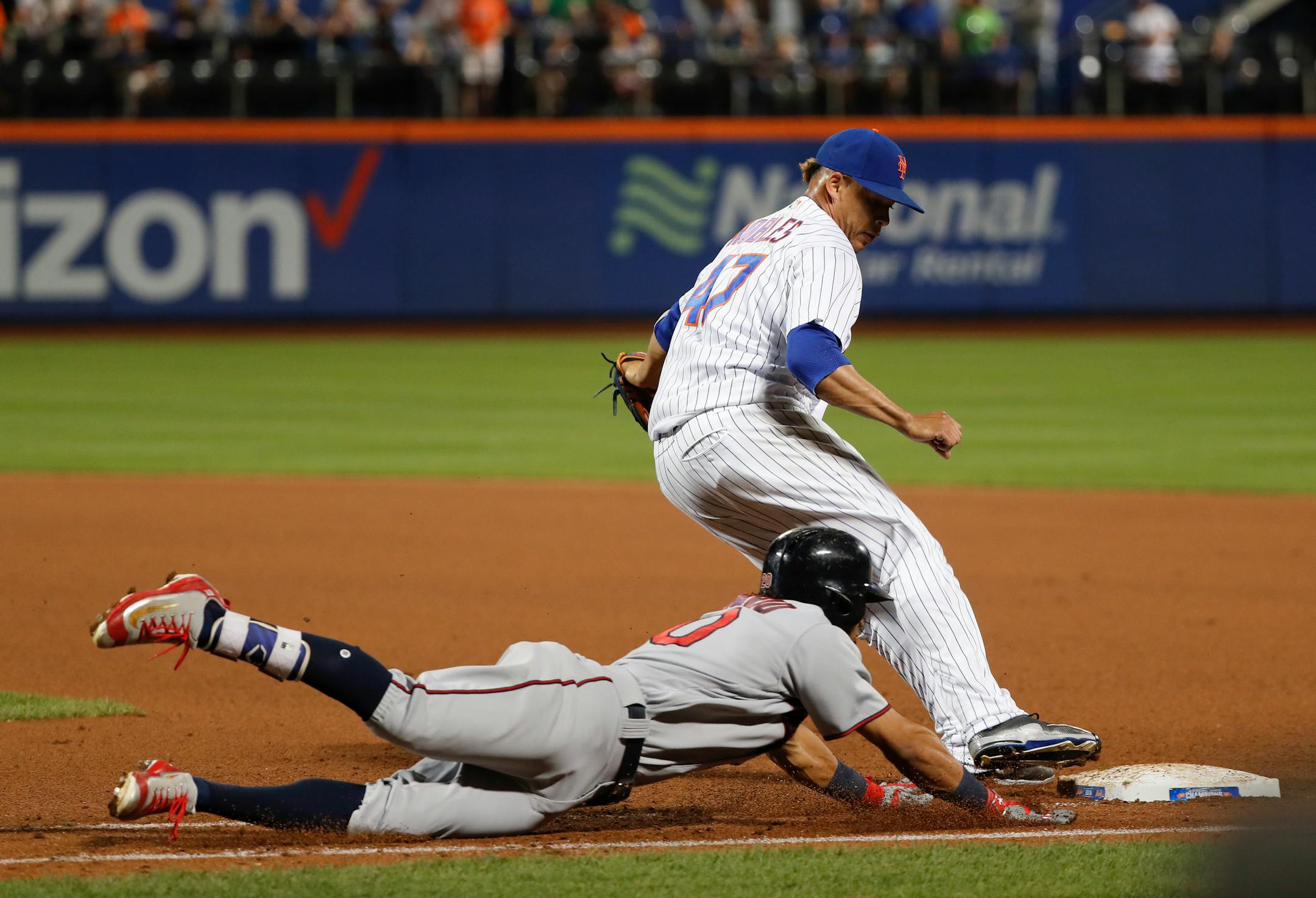 New York Mets relief pitcher Hansel Robles (47) beats Minnesota Twins' Eddie Rosario (20) to the bag as Rosario tries to reach first safely sliding during the tenth inning of a baseball game, Saturday, Sept. 17, 2016, in New York. (AP Photo/Julie Jacobson)
