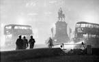 Double-decker buses circle the Prince Albert statue at Holborn Circus in London, England, in the smog at night on Dec. 6, 1952. The heavy smog, caused