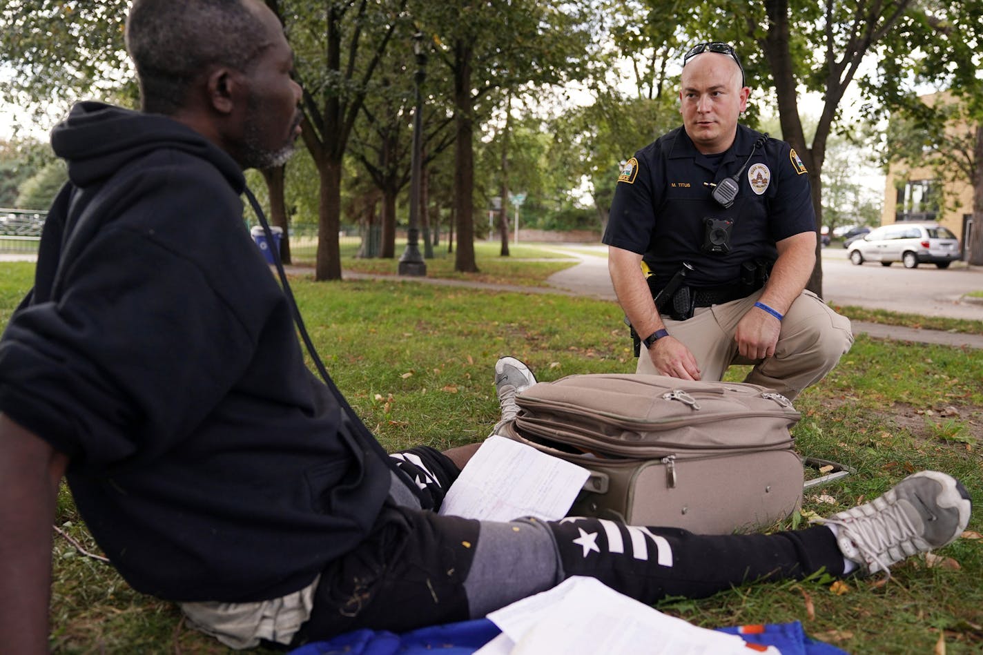 Officer Justin Tiffany checked the well being of a man sleeping in a park.] ANTHONY SOUFFLE &#xef; anthony.souffle@startribune.com A pair of social workers from Regions Hospital worked alongside St. Paul police responding to mental health crisis calls Sept. 13, 2018 in St. Paul.