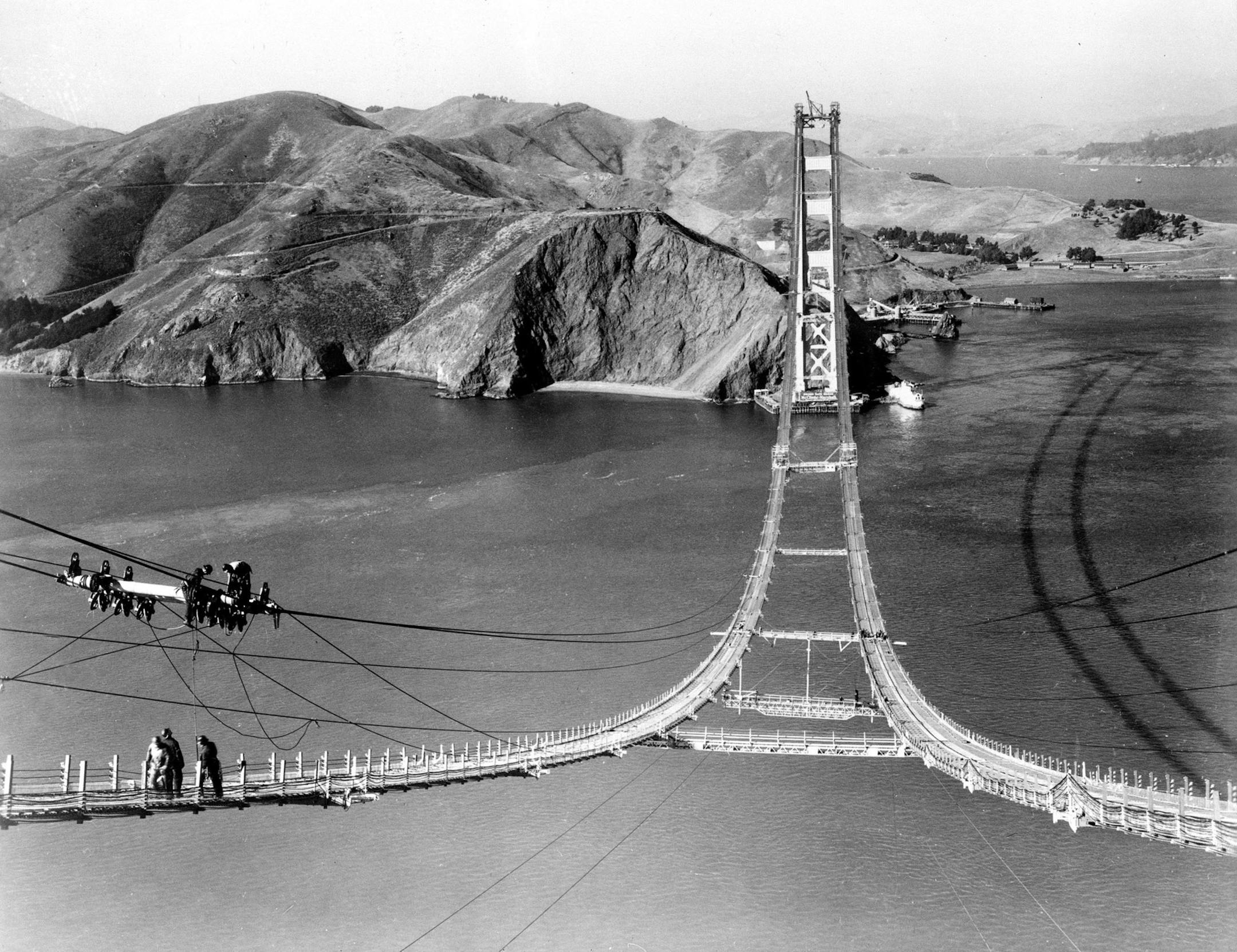 File - In an Oct. 25, 1935 file photo, workers complete the catwalks for the Golden Gate Bridge, prior to spinning the bridge cables during construction in San Francisco. The bridge was heralded as an engineering marvel when it opened in 1937. It was the world's longest suspension span and had been built across a strait that critics said was too treacherous to be bridged. As the iconic span approaches its 75th anniversary, the engineers who have overseen it all these years say keeping it up and