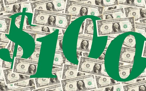 Green number $100 nestled by dollar bills