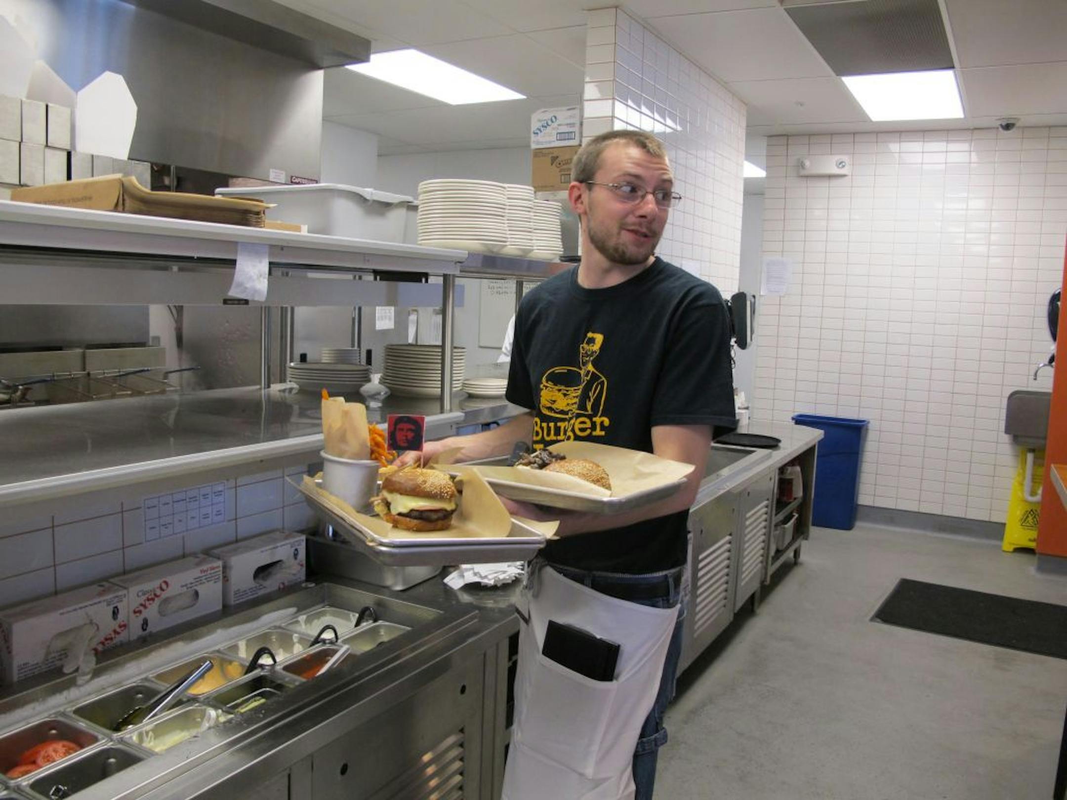 Mark Jamrozek , at the Burger Jones in Burnsville, serves the Cubano burger, complete with a Che Guevara flag.