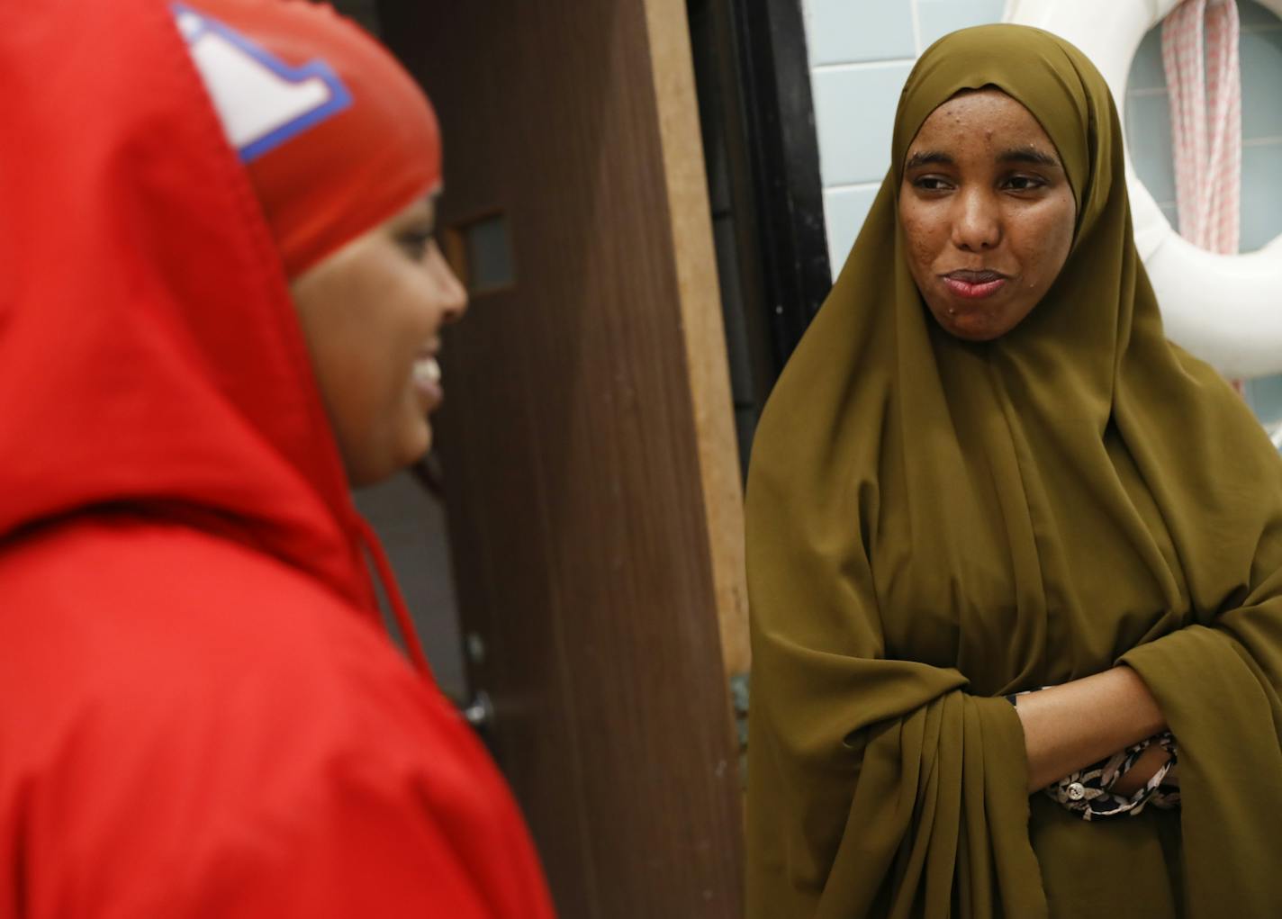 Nimo Gohe, right, chatted with Suhan Mohamed before a swim meet at Apollo High School in St. Cloud, Minn., on Thursday, October 5, 2017. Gohe was not swimming in this meet but cheered on her teammates. Nimo Gohe and Suhan Mohamed just learned to swim this summer and are now on the Apollo High School swim team. ] RENEE JONES SCHNEIDER &#x2022; renee.jones@startribune.com