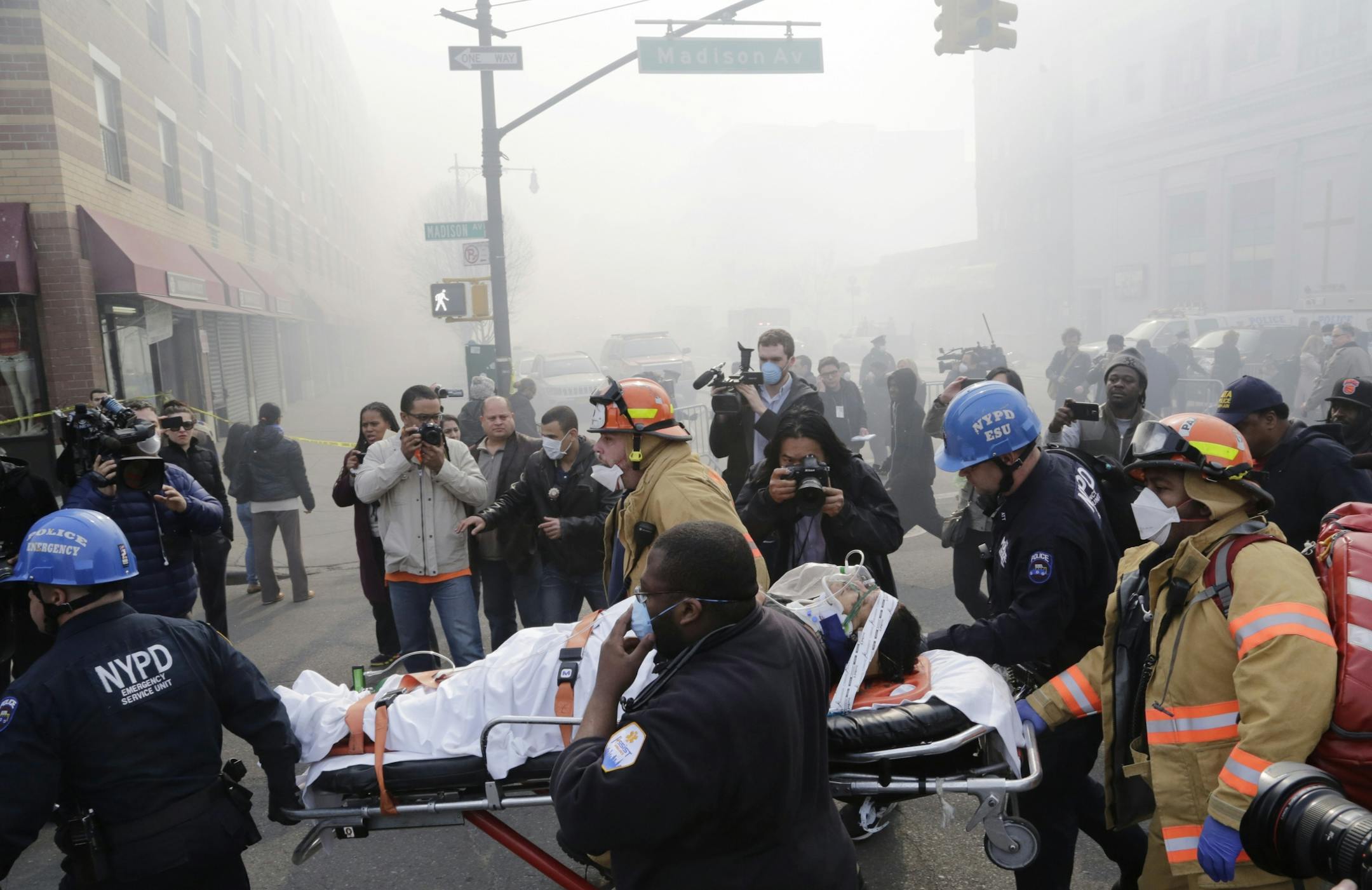 Rescue workers remove an injured person on a stretcher after a possible explosion and building collapse in the East Harlem neighborhood of New York, Wednesday, March 12, 2014