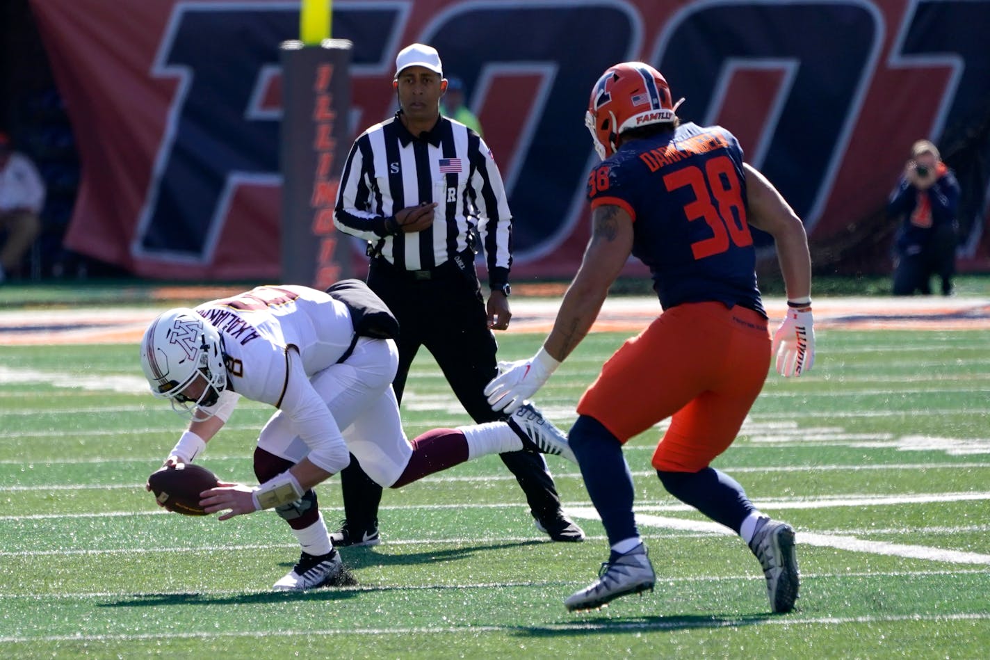 Minnesota quarterback Athan Kaliakmanis stumbles before being tackled for a loss by Illinois linebacker Isaac Darkangelo during the second half of an NCAA college football game Saturday, Oct. 15, 2022, in Champaign, Ill. (AP Photo/Charles Rex Arbogast)