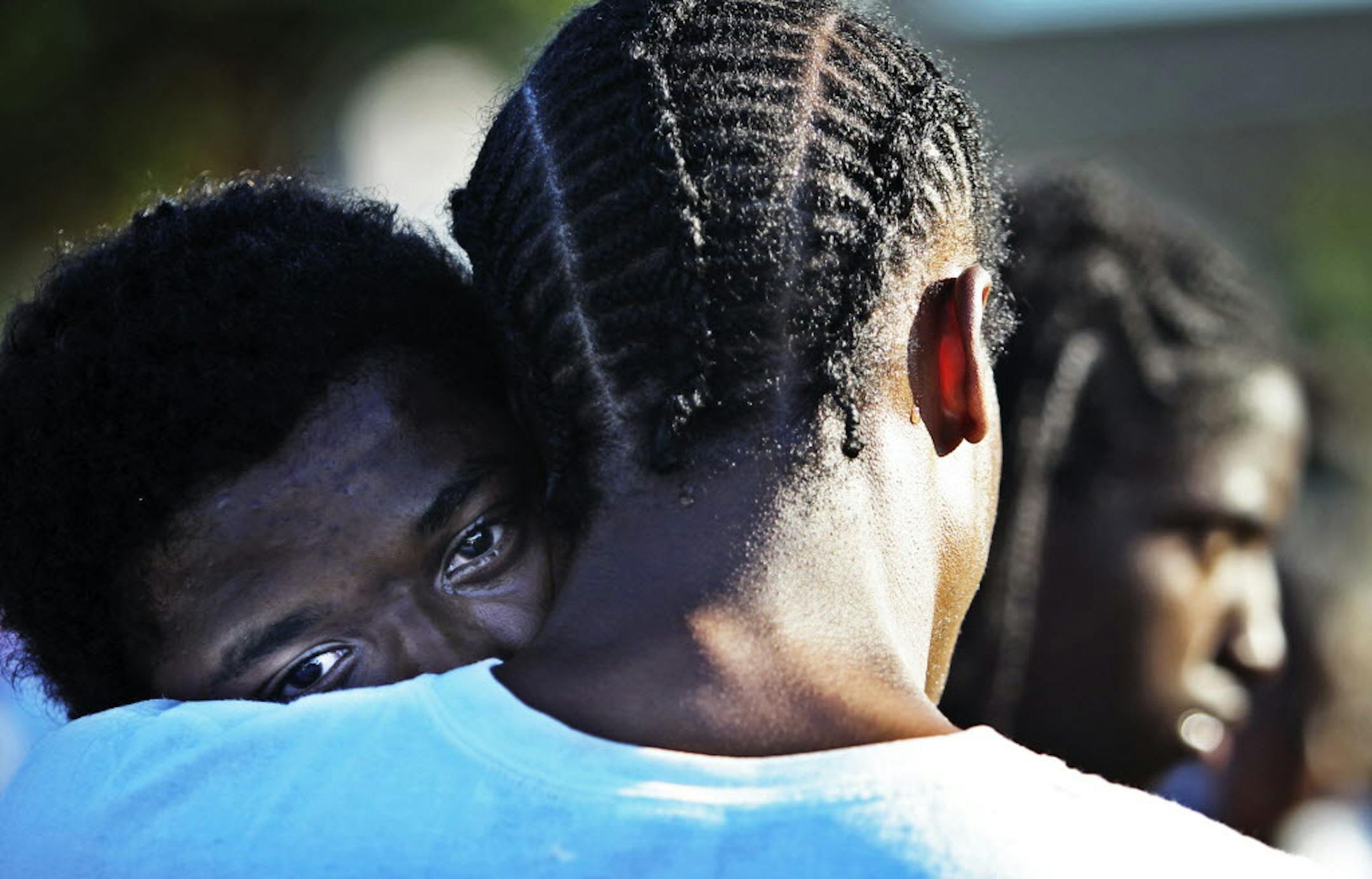 Jose Morgan, middle, held his grieving son, Malik, 13, during a peace vigil Thursday in north Minneapolis.