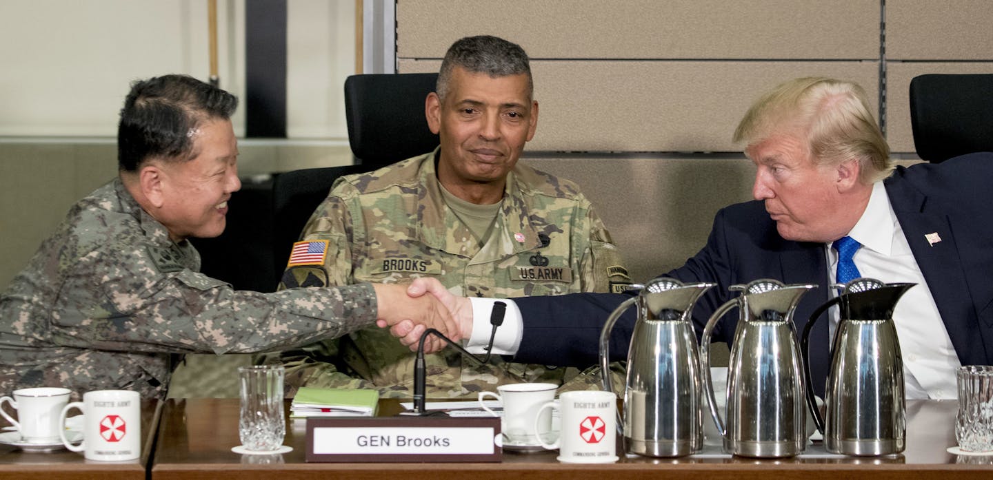 U.S. President Donald Trump, accompanied by United States Forces Korea Commander Gen. Vincent Brooks, center, shakes hands with South Korean Gen. Kim Byung-joo during an operational briefing at the eighth Army Operational Command Center at Camp Humphreys in Pyeongtaek, South Korea, Tuesday, Nov. 7, 2017. Trump is on a five-country trip through Asia traveling to Japan, South Korea, China, Vietnam and the Philippines. (AP Photo/Andrew Harnik)