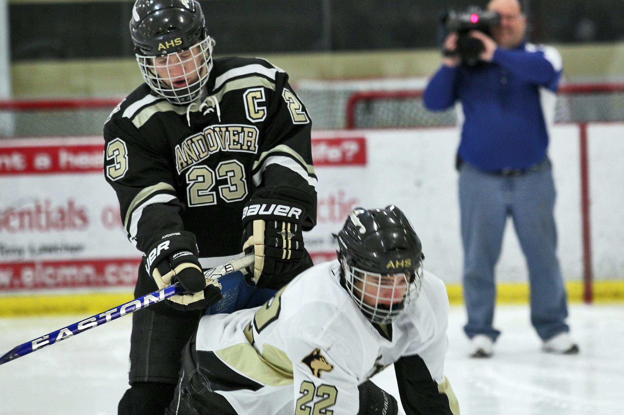 The Minnesota High School Athletic Association will announce stricter rules and penalties for hockey players who are called for checking a player in the back or sending players flying into the boards of a rink. Officials conducted a video session with Andover hockey players to demonstrate the change in rules.Playeers Jake Harmon, (23) and Calvin Rak (22) deomonstrated the penalty of checking from behind as Channel 45 Executive Sports Director Dennis Silva filmed in the background. ](MARLIN LEVIS