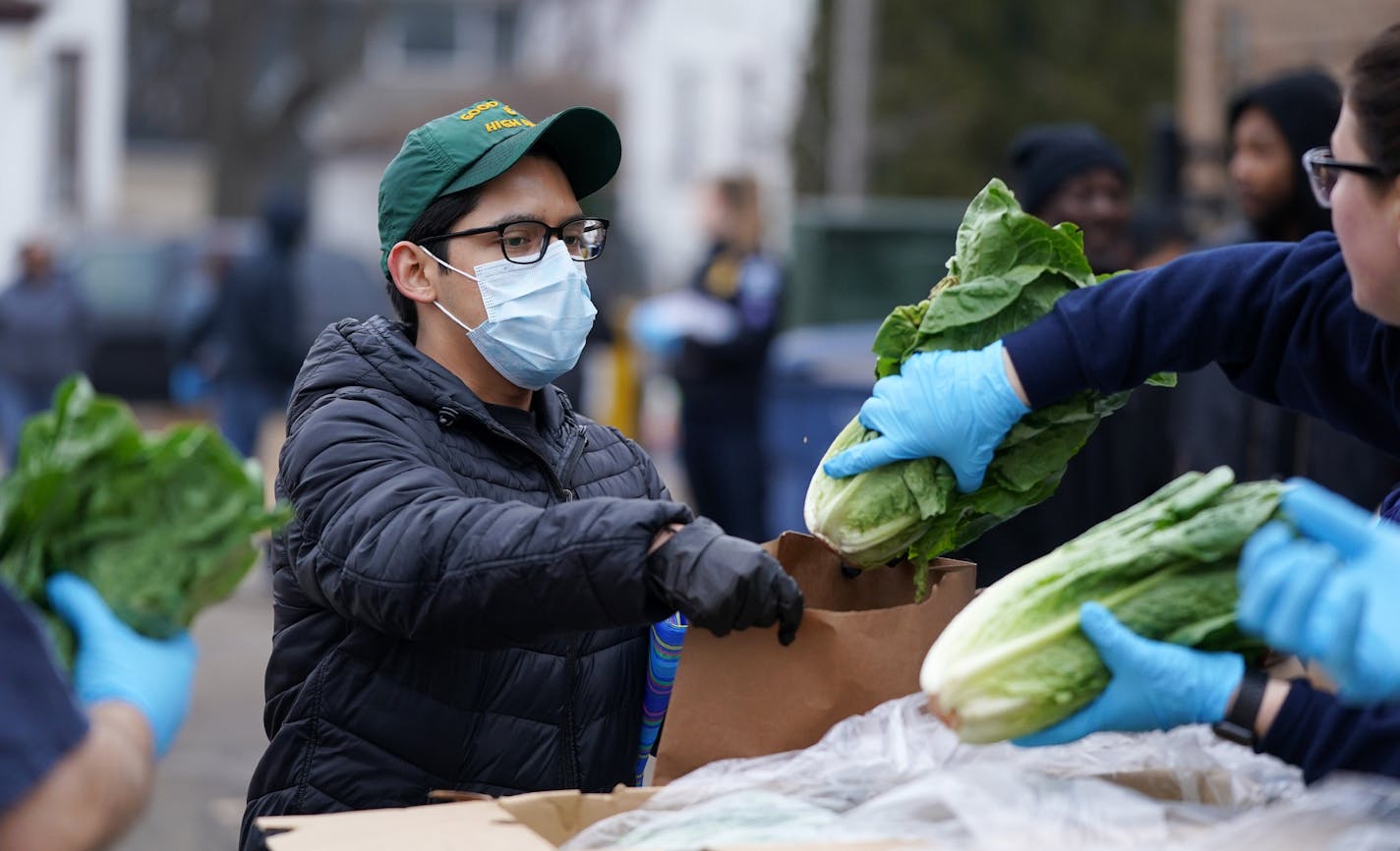 A man wore a mask as he was given a head of lettuce during the free grocery giveaway event Wednesday at the Minneapolis Police Activities League. ] ANTHONY SOUFFLE &#x2022; anthony.souffle@startribune.com The Minneapolis Police Department, University of Minnesota Extension, Metro Transit Police Department, and Society of St. Vincent De Paul offered a free grocery giveaway event for those impacted by the Coronavirus closures Wednesday, March 18, 2020 at the Minneapolis Police Activities League in