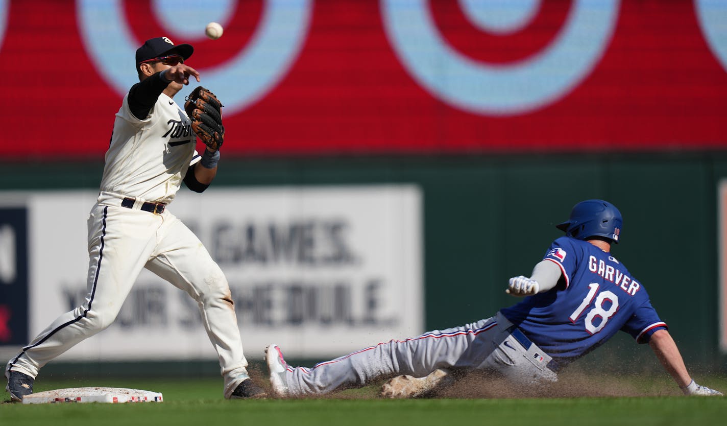 Minnesota Twins second baseman Jorge Polanco (11) turns a double plays as Texas Rangers catcher Mitch Garver (18) slides into second base in the 10th inning in Minneapolis, Minn., on Monday, Aug. 28, 2023. Texas Rangers take on the Minnesota Twins at Target Field.] RICHARD TSONG-TAATARII • richard.tsong-taatarii @startribune.com