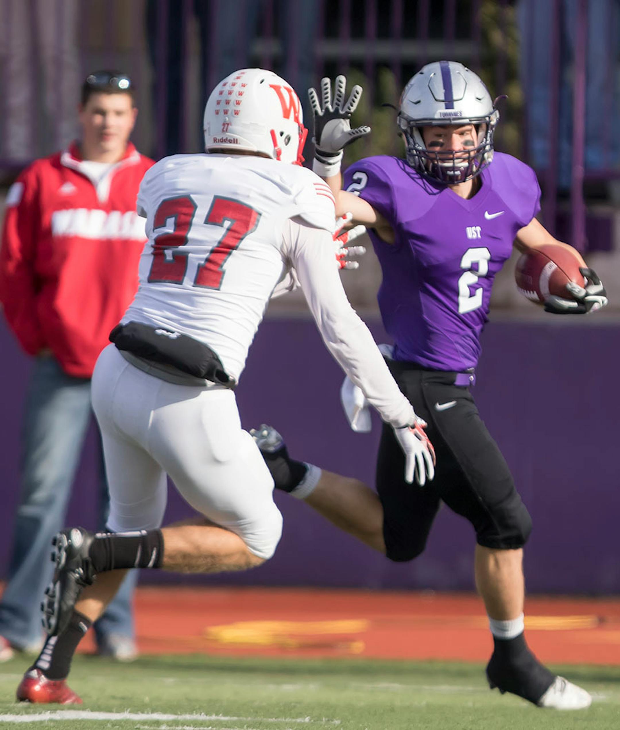 St. Thomas receiver Nick Waldvogel (2) runs past Wabash kicker Derek Fox (27) on his way to a punt return touchdown as the University of St. Thomas Tommies hosted the Wabash College Little Giants on December 5, 2015.