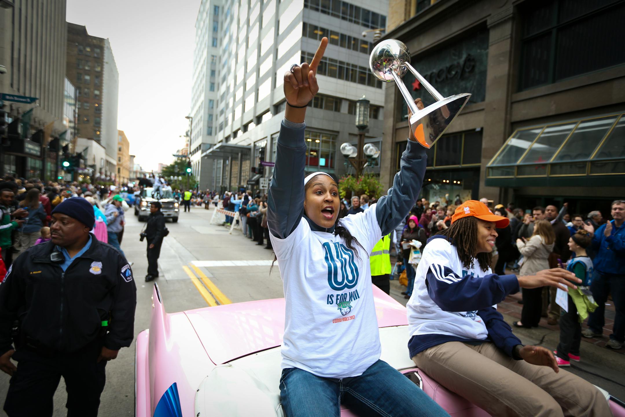Lynx player Maya Moore raised up the trophy for the fans to see during a championship celebration parade for the WNBA champions on Monday, October 14, 2013