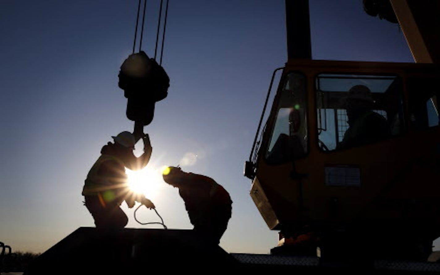 Iron workers set up a crane to move steel for the construction of buildings on the site of Essar Steel Minnesota's taconite mine project in Nashwauk, Minn. ] LEILA NAVIDI leila.navidi@startribune.com / BACKGROUND INFORMATION: Friday, October 31, 2014. Essar Steel Minnesota recently ramped up construction on an $1.8 billion taconite plant after securing the funding needed to complete the project. The plant endured several delays over the past two years as funds periodically ran dry and some contr