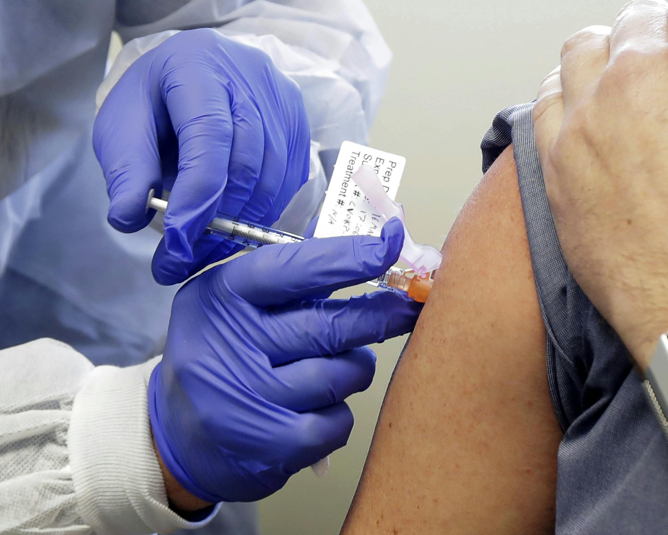 FILE - In this March 16, 2020, file photo, Neal Browning receives a shot in the first-stage safety study clinical trial of a potential vaccine for COVID-19, the disease caused by the new coronavirus, at the Kaiser Permanente Washington Health Research Institute in Seattle. (AP Photo/Ted S. Warren, File) ORG XMIT: MERc95848f2a443b8b9a8e0fc241a150