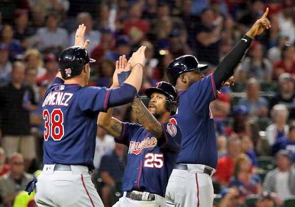 Minnesota Twins' Chris Gimenez (38), Byron Buxton (25) and Kennys Vargas, rear, celebrate scoring on a bases clearing double by Brian Dozier in the fi