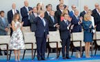 U.S. President Donald Trump salutes while French President Emmanuel Macron, 2nd right, his wife, Brigitte Macron, right, and U.S. First Lady Melania T