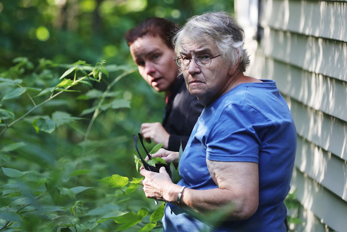 Janice Hiller and her daughter, Dawn Hiller, said they are still tortured by guilt over the treatment of their father, Wally, who died at Superior View Assisted Living before the facility shut down. Before the family could move Wally to another residential care facility, he died of complications related to a urinary tract infection &#xf1; just four months after his admission to Superior View. Here, Janice, front, and Dawn Hiller walk through overgrown vegetation while trying to get a look into t