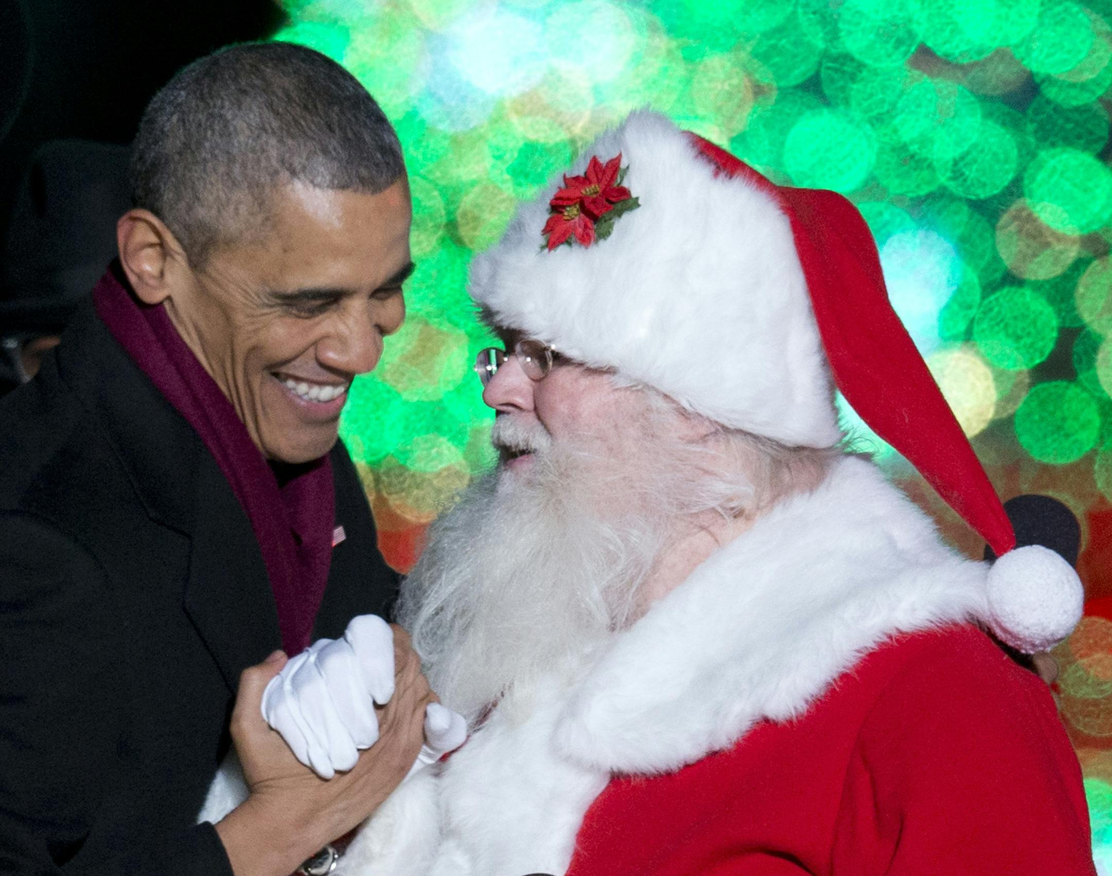 President Barack Obama greets Santa on stage during the National Christmas Tree lighting ceremony at the Ellipse near the White House in Washington, Thursday, Dec. 4, 2014. (AP Photo/Carolyn Kaster) ORG XMIT: MIN2014121216493754