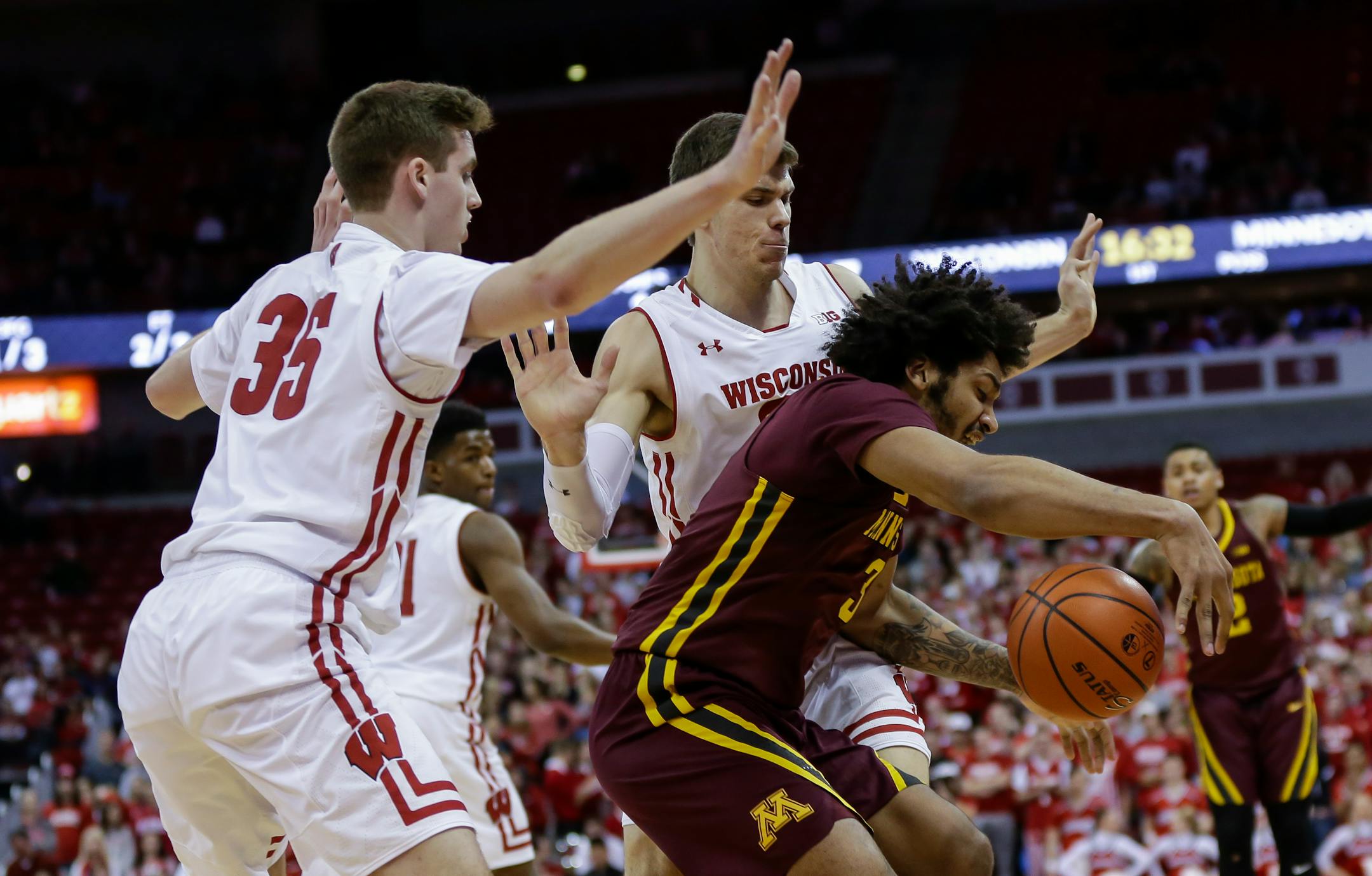 Wisconsin's Nate Reuvers (35) and Ethan Happ, behind, trap Gophers forward Jordan Murphy during the first half Monday.
