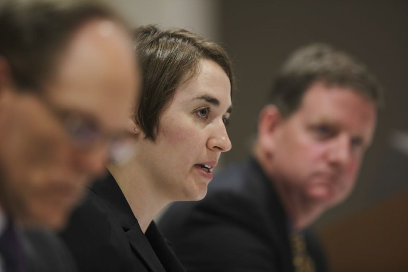 Hennepin County Elections Supervisor Ginny Gelms spoke at the beginning of the hearing. At left was Hennepin County Auditor Mark Chapin and Dan Rogan, Hennepin County Attorney, was on the right. The hearing took place in the basement auditorium in the Hennepin County Government Center Thursday afternoon.